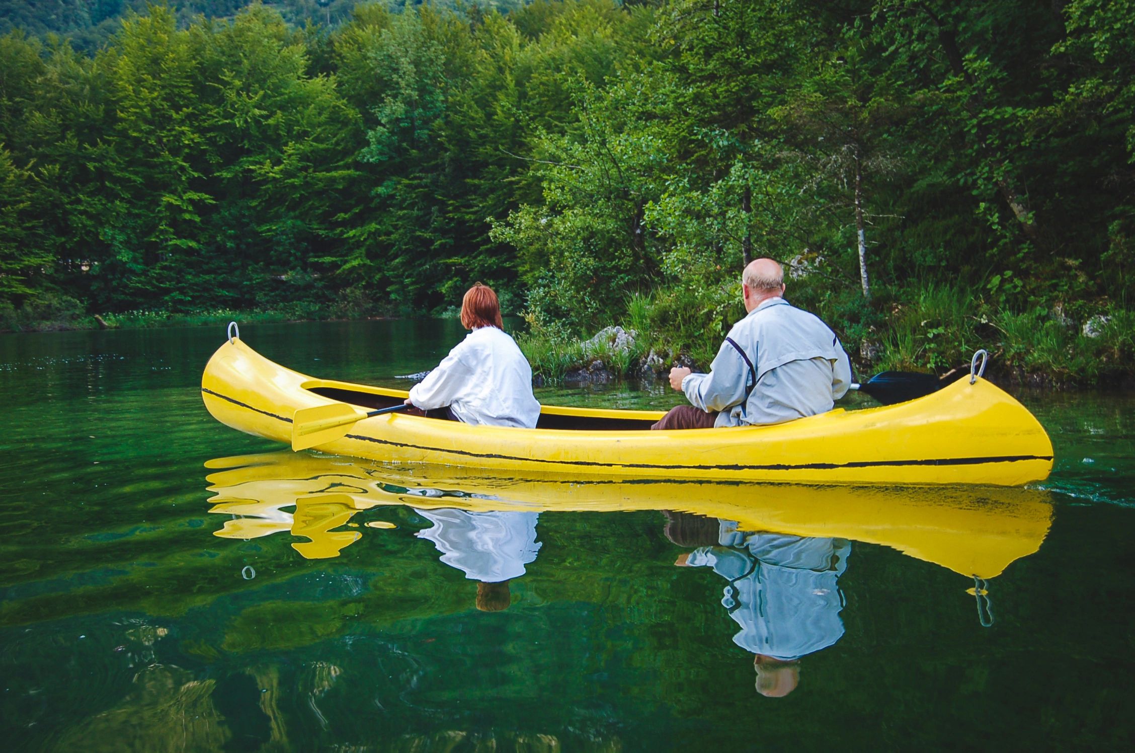 Senior couple paddling in a canoe on a lake